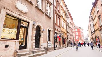 Eine Straße mit historischen Gebäuden, einem Laden mit Schaufenstern und Fußgängern.