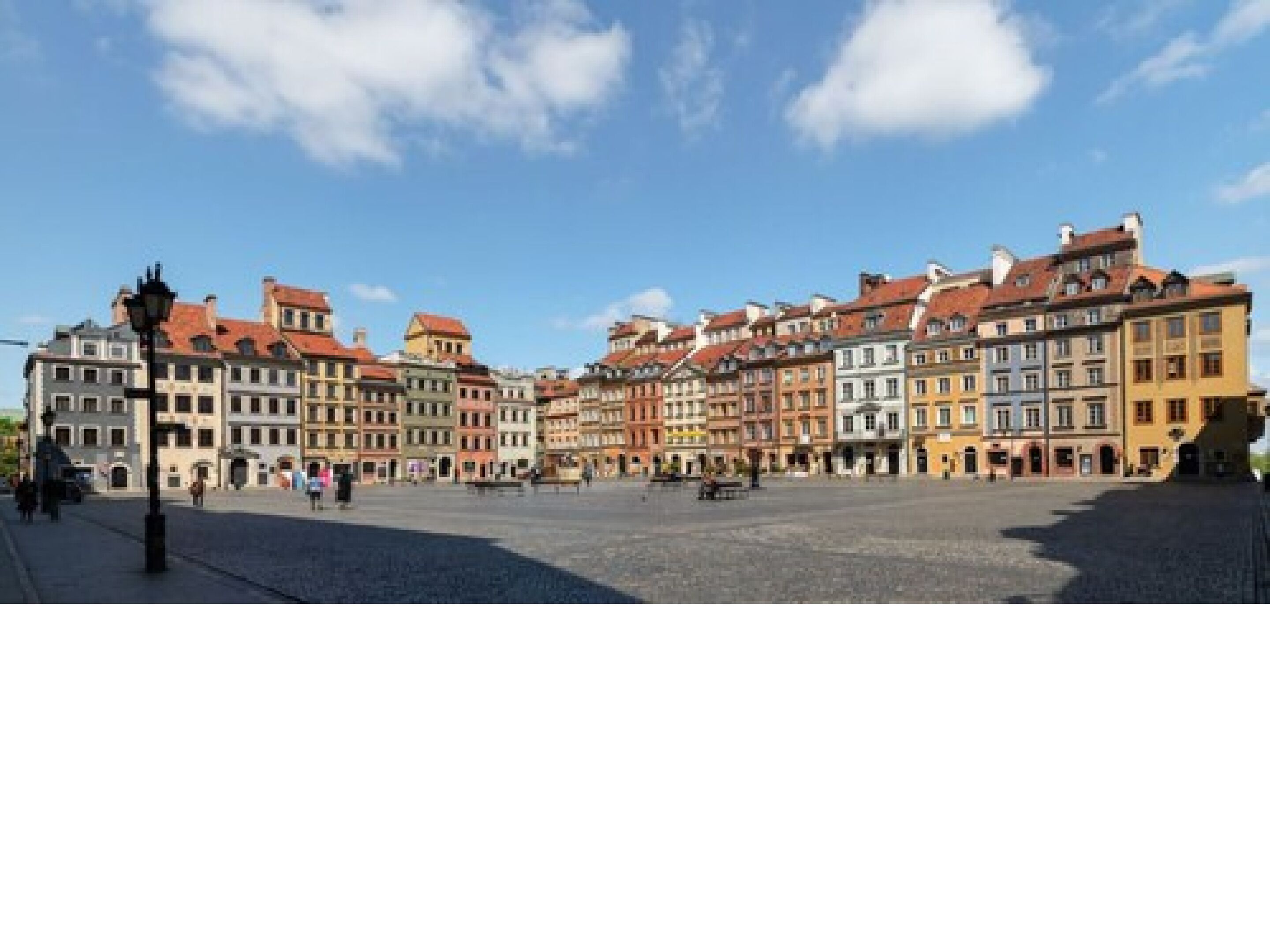 A historic square with colorful buildings, a cobblestone ground, and a few people.