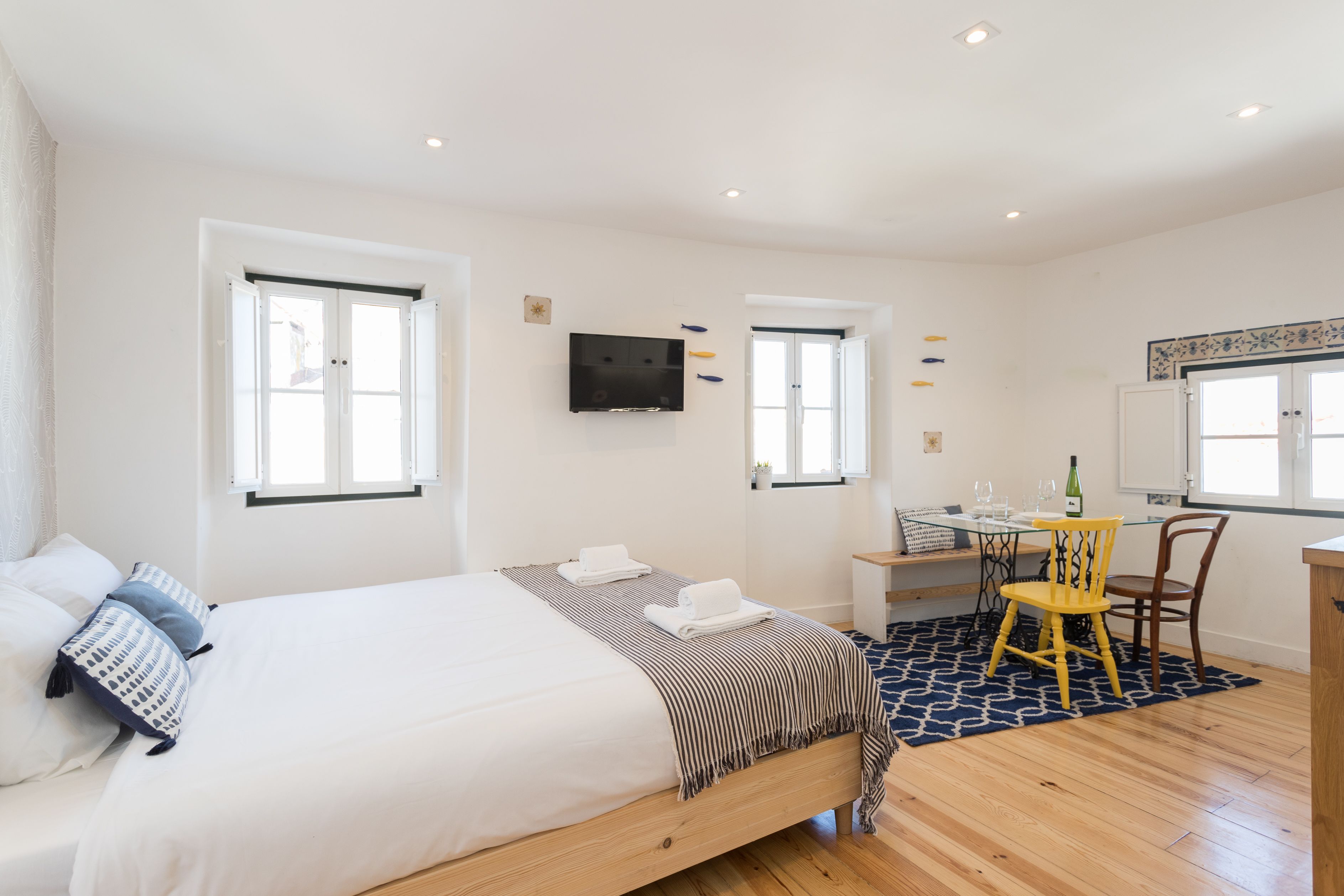 Un dormitorio con cama, escritorio, silla y televisor.