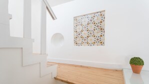 Een trap met houten treden en een witte muur met een lijstwerk bloemwerk.