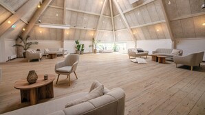Un loft amplio con techos altos, pisos de madera y diversas opciones de asientos, incluyendo sofás y sillones.