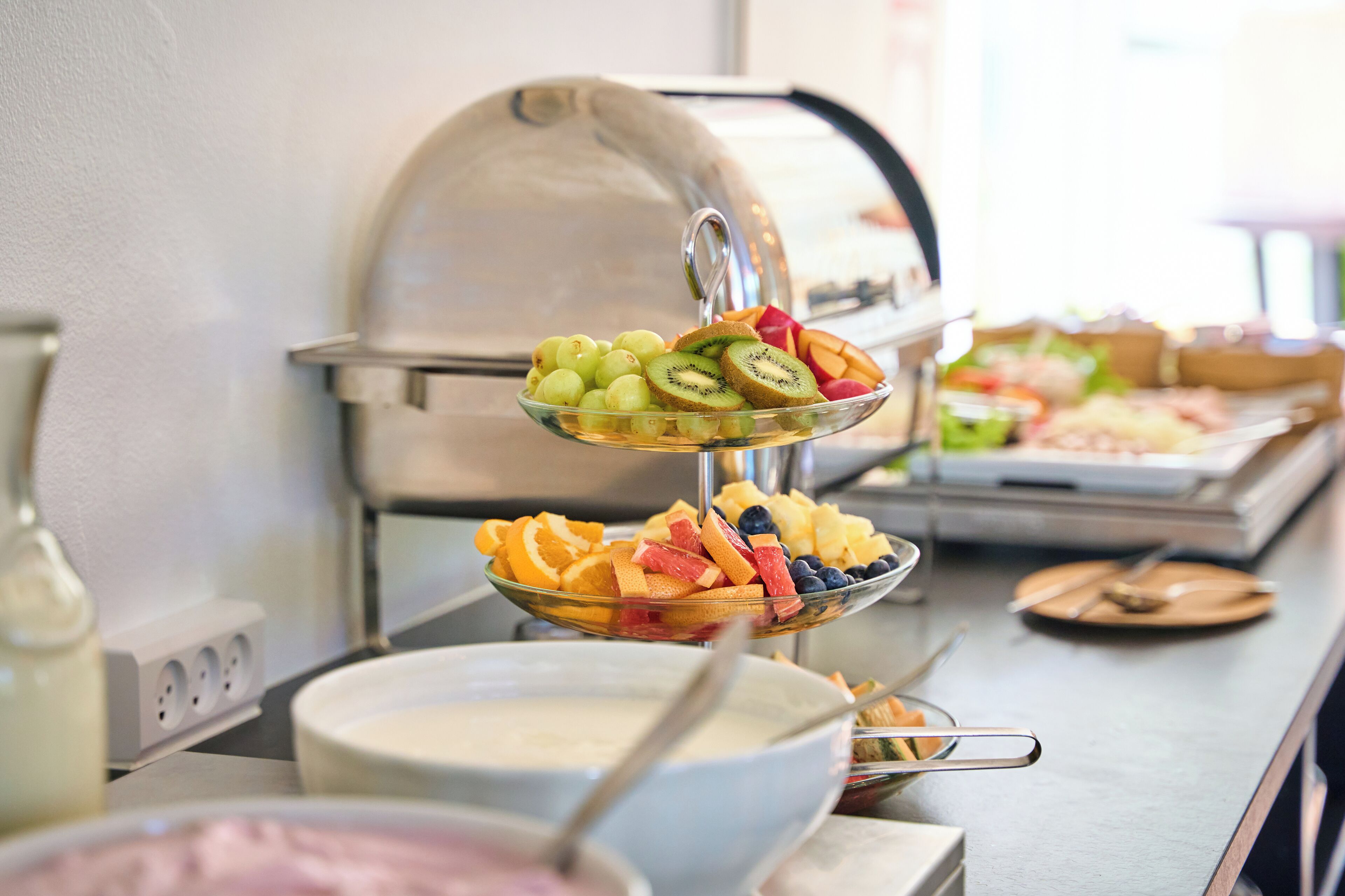 Un dispositiu de buffet amb una varietat de fruites i una estació d'aliments coberta.