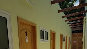 A corridor with numbered doors, a small window, and a tiled floor. - Sharp Guest House (Accra)