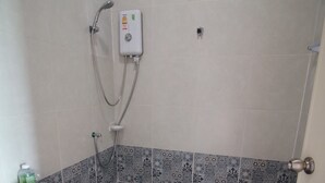 A bathroom with a toilet, a shower, and a wall-mounted control panel. - BarandBed URT (Phunphin)