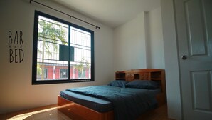 A bedroom with a large window, a bed, a wardrobe, and a door. - BarandBed URT (Phunphin)