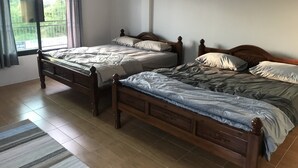 A room with two wooden beds, a window with curtains, and a tiled floor. - BarandBed URT (Phunphin)
