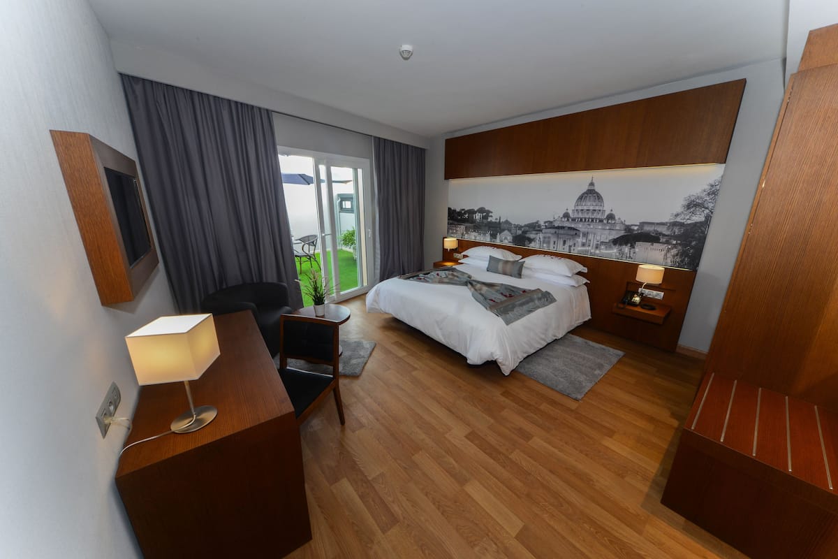 Deluxe kamer | Luxe beddengoed, een kluis op de kamer, een bureau
