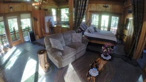 A cozy cabin interior with a sofa, a bed, and a dining area. - Lanzarotta Bed and Breakfast (Eugene)