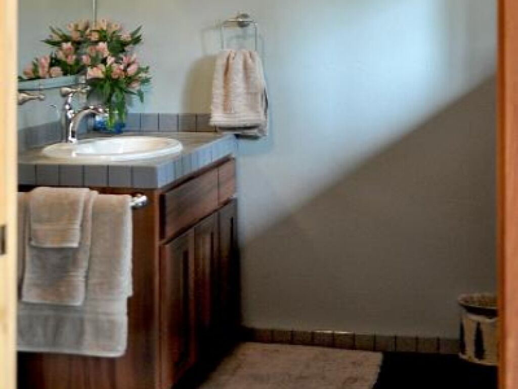 A bathroom with a sink, mirror, and towel rack.