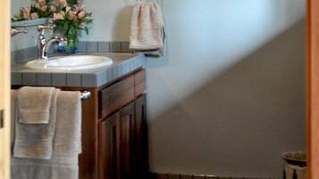 A bathroom with a sink, mirror, and towel rack.
