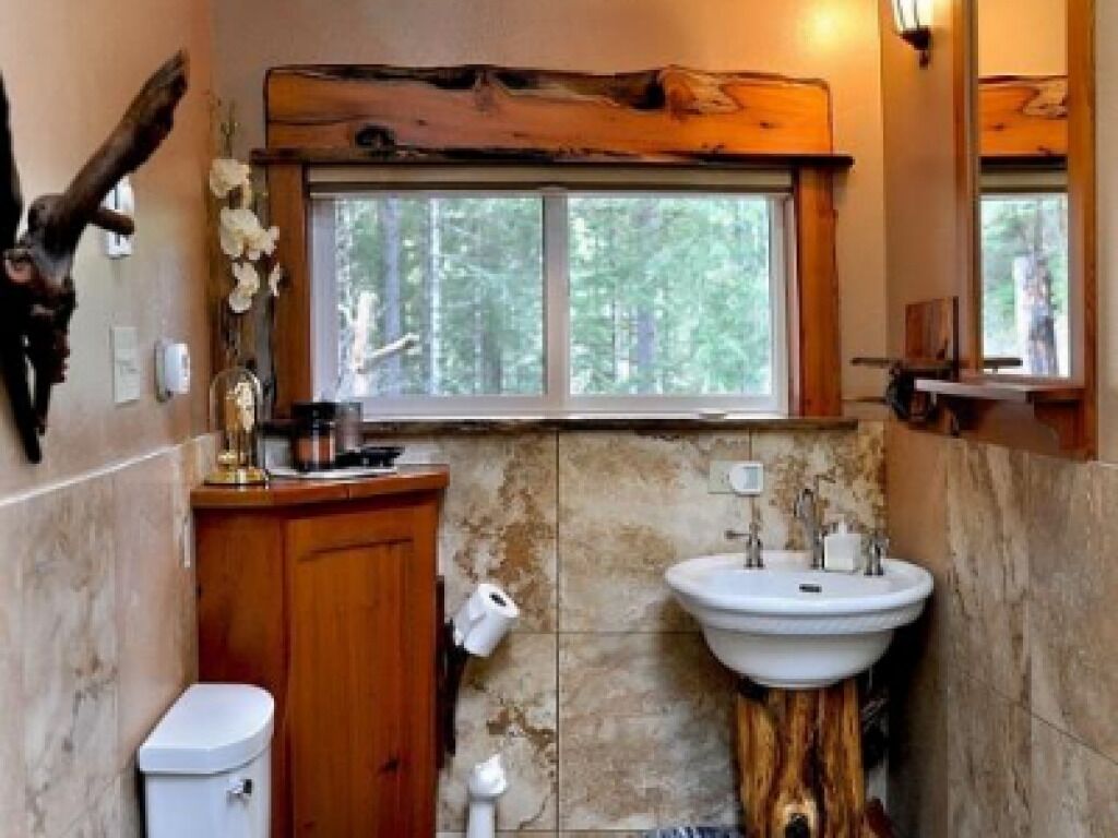 A bathroom with a wooden vanity, a sink, and a toilet.
