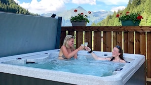 Un bain à remous où deux personnes trinquent.