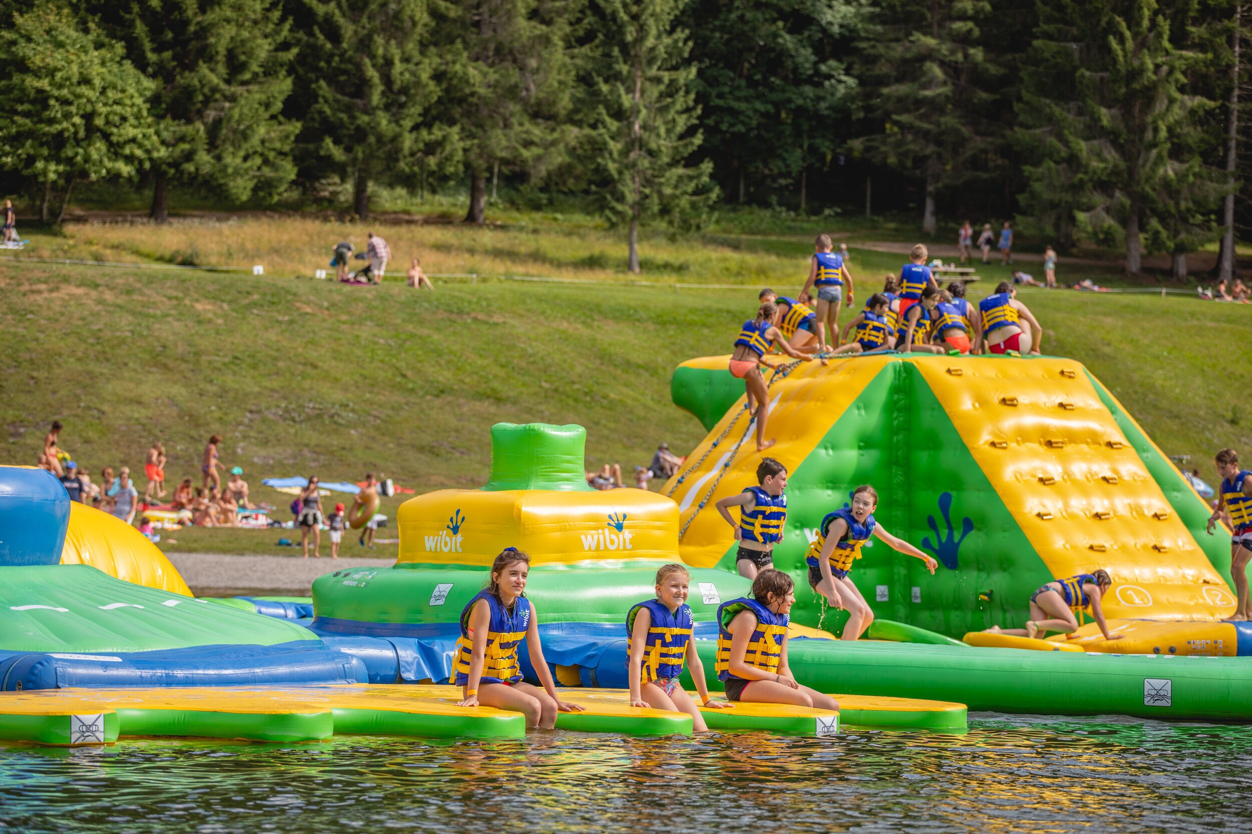 A water park with inflatable play structures and people enjoying the facilities.
