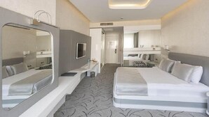 A modern hotel room with a large bed, a bedside table, a mirror, and a small desk with a chair. - White Line Boutique Hotel (Elazig)