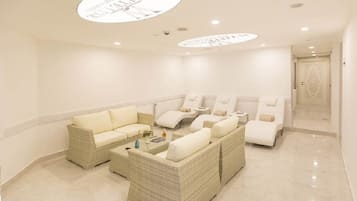 Relax in this stylish room with a large sofa, polished floor, and recessed lighting.