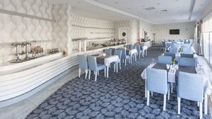 A spacious dining area with a patterned carpet, white walls, and a long counter with various amenities. - White Line Boutique Hotel (Elazig)