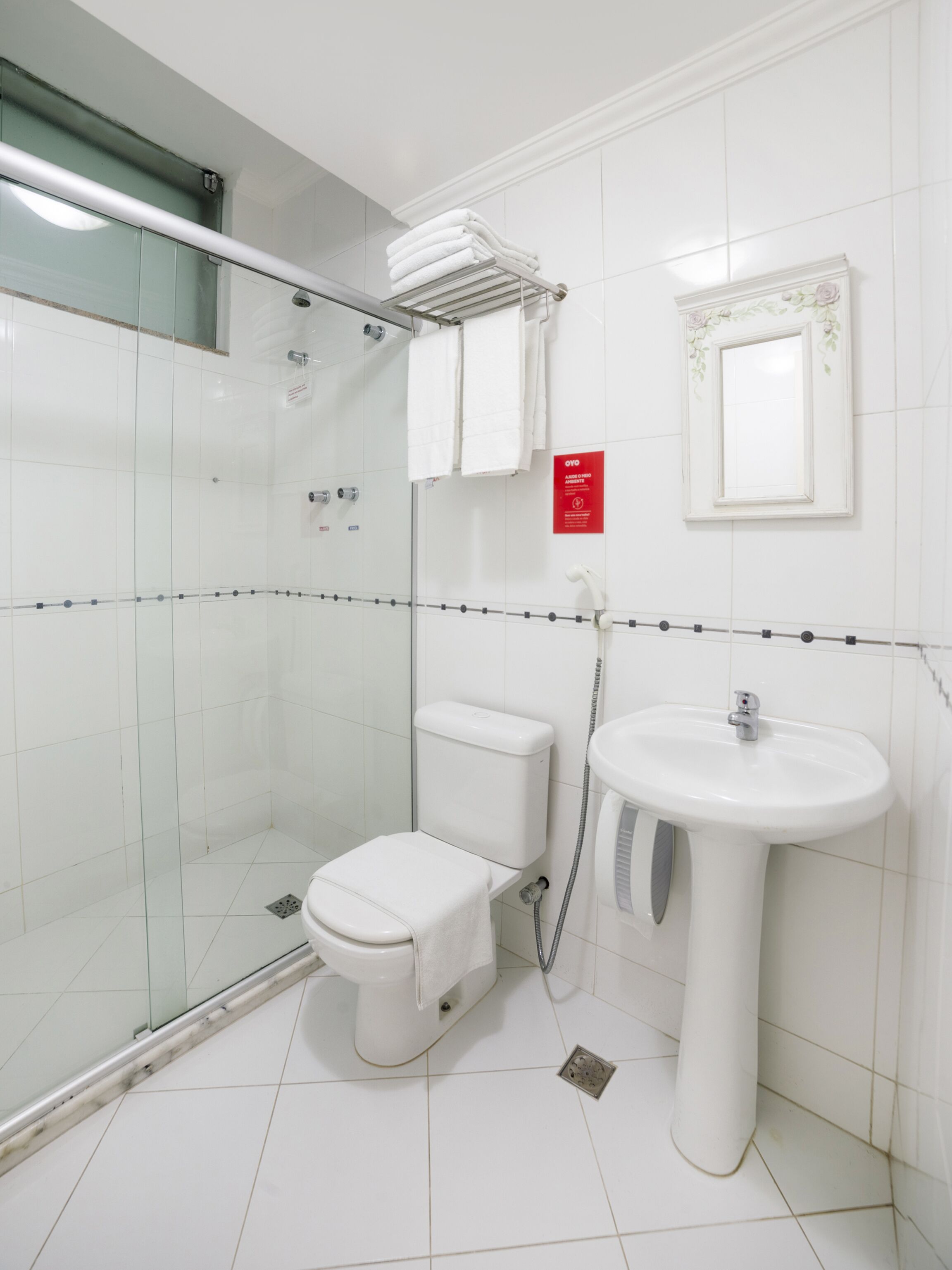 Un bagno moderno con cabina doccia in vetro, un water e un lavabo.