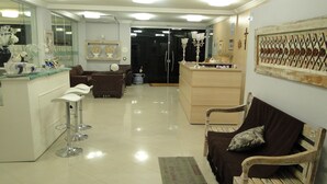 A spacious living area with a bar, seating, and a reception desk. - Videiras Palace Hotel (Cachoeira Paulista)