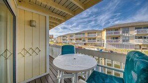 A balcony with a table and chairs, overlooking a row of multi-story buildings with balconies. - Canal Views! Free Beach Service, Pet Friendly! Sandpiper Cove 4100! (Destin)