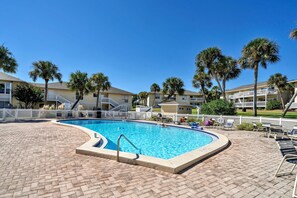 A swimming pool with a brick deck, surrounded by palm trees and a white fence. - Canal Views! Free Beach Service, Pet Friendly! Sandpiper Cove 4100! (Destin)