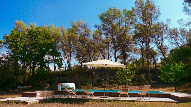 A pool area with lounge chairs and an umbrella, surrounded by trees. - Near Aix-en-provence, country house, with pool without vis-à-vis (Aix-en-Provence)