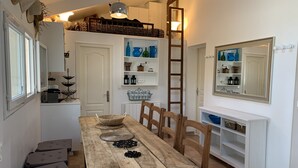 A dining area with a wooden table, chairs, and a white console table with shelves. - Near Aix-en-provence, country house, with pool without vis-à-vis (Aix-en-Provence)