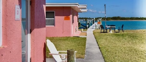 A row of pink motel buildings with a clear view of the ocean.