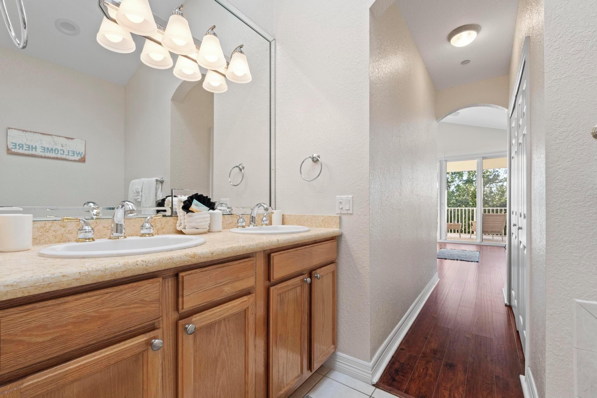 A modern bathroom with a double sink, wooden cabinets, and a large mirror.