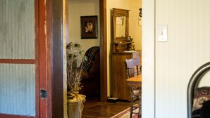 A wooden door leading to a room with a dining table, chairs, and a rug. - Ranch House in the Elkhorn Mountains (Clancy)