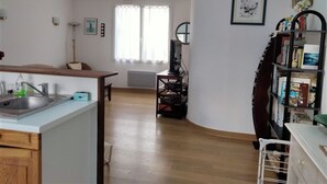 Une cuisine équipée d’un évier, d’une table à manger et d’une bibliothèque.