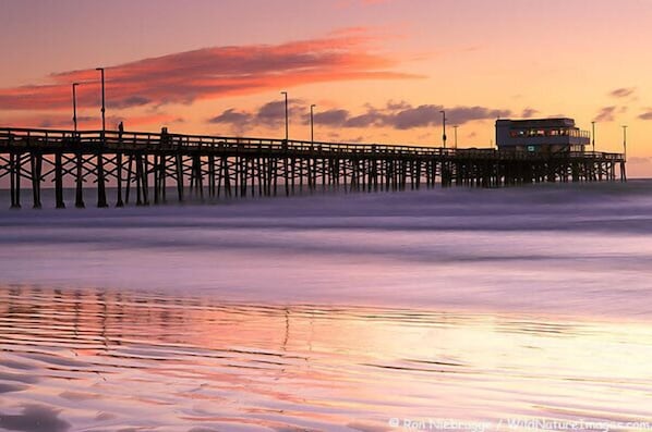 A pier extending into the water with a building at the end. - Newly built + Ocean View + Steps to Sand (Newport Beach)
