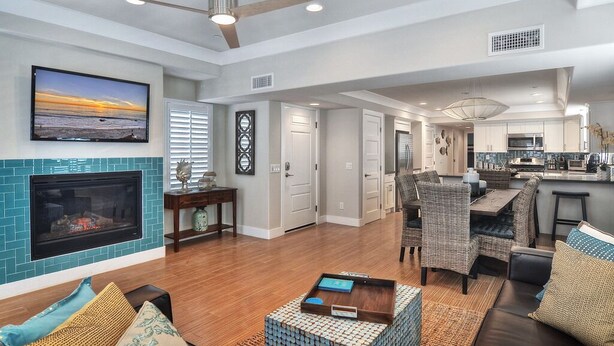 A spacious living area with a fireplace, dining area, and kitchen. - Newly built + Ocean View + Steps to Sand (Newport Beach)
