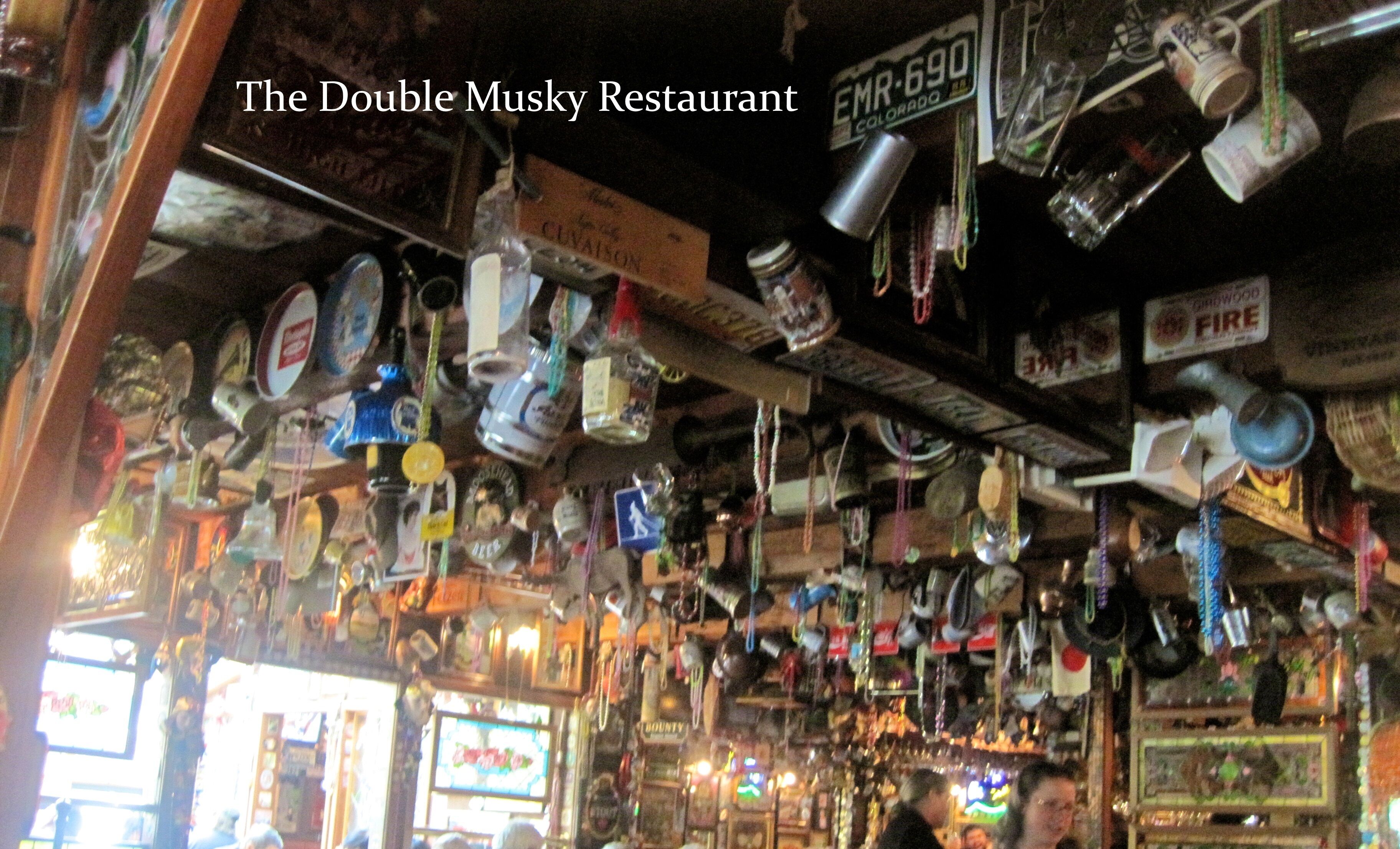 A cluttered interior of The Double Musky Restaurant with various items hanging from the ceiling.