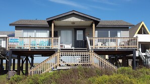 A two-story house with a balcony on each floor, a front door, and a sign advertising Bluewater Resort Rentals.