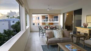 A spacious balcony with a dining area, a sofa, and a coffee table.