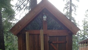 A wooden treehouse with a ladder, built on a sturdy platform, surrounded by trees. - Beautiful Donner Lake Home  (Truckee)
