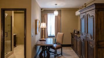 Une pièce comprenant une table à manger, une chaise, un lustre, un buffet et une fenêtre avec des rideaux.
