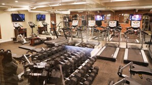 Une salle de sport équipée de tapis de course, de vélos elliptiques et de poids libres.