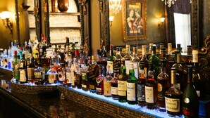 Un bar où une variété de bouteilles d’alcool sont exposées sur des étagères.