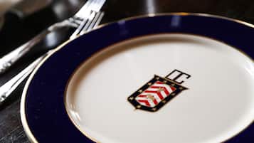 A close-up of a white plate with a blue rim and a decorative emblem.