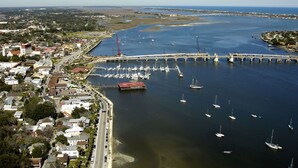 A coastal town with a marina, a bridge, and residential buildings.