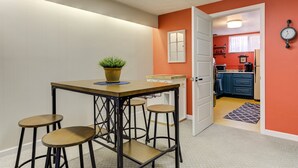 Une cuisine avec un mur rouge, une porte blanche et une horloge.