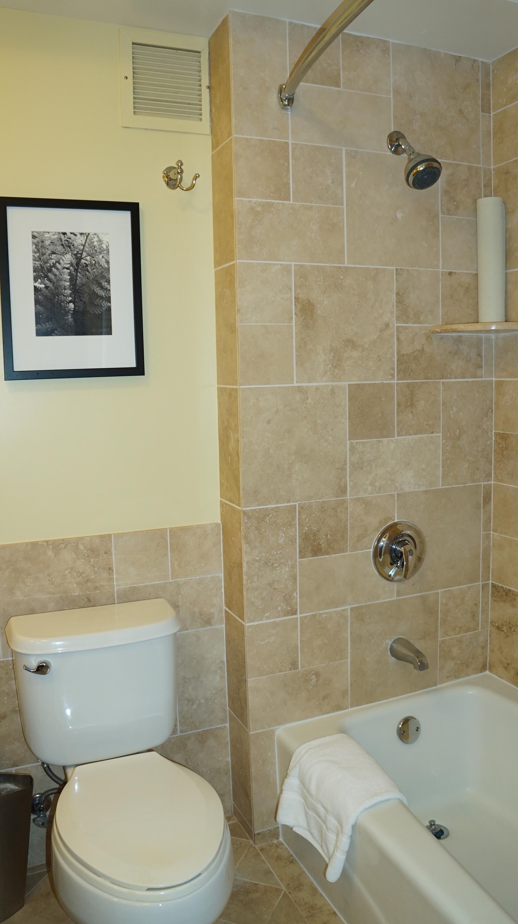 attractive travertine tile surrounds the combination tub & shower.