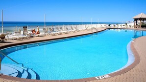 A swimming pool with a clear blue sky and a view of the ocean.