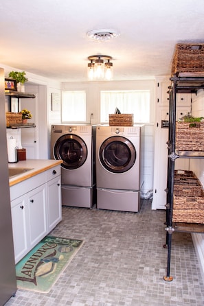 Convenient laundry facilities include two front-loading washing machines and a sink.