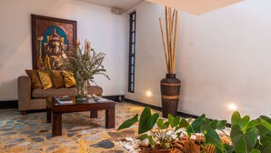 Uma sala de estar aconchegante com sofá, mesa de centro e plantas em vasos.