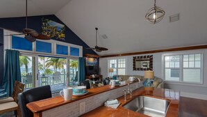 A spacious kitchen with a large island, a dining area, and a view of the outdoors.