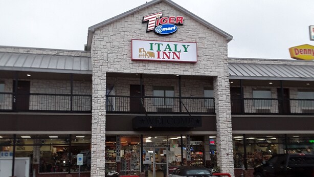 A building with a sign for Italy Inn and a Tiger Mart.