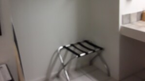 A small kitchenette with a metal drying rack, a white countertop, and a hanging clothes rack. - Italy Inn (Italy)