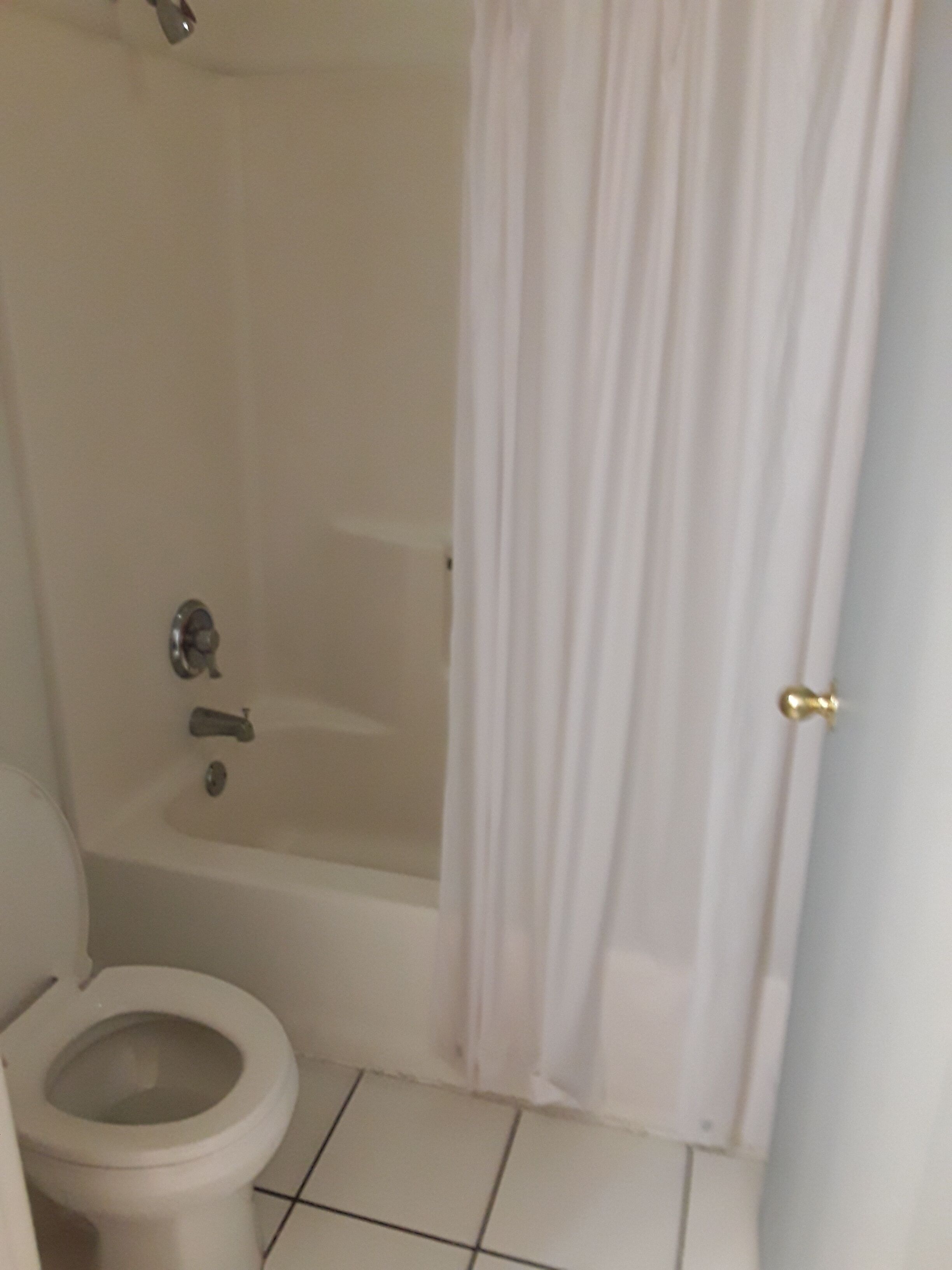 Un baño con bañera, inodoro y cortina de ducha.